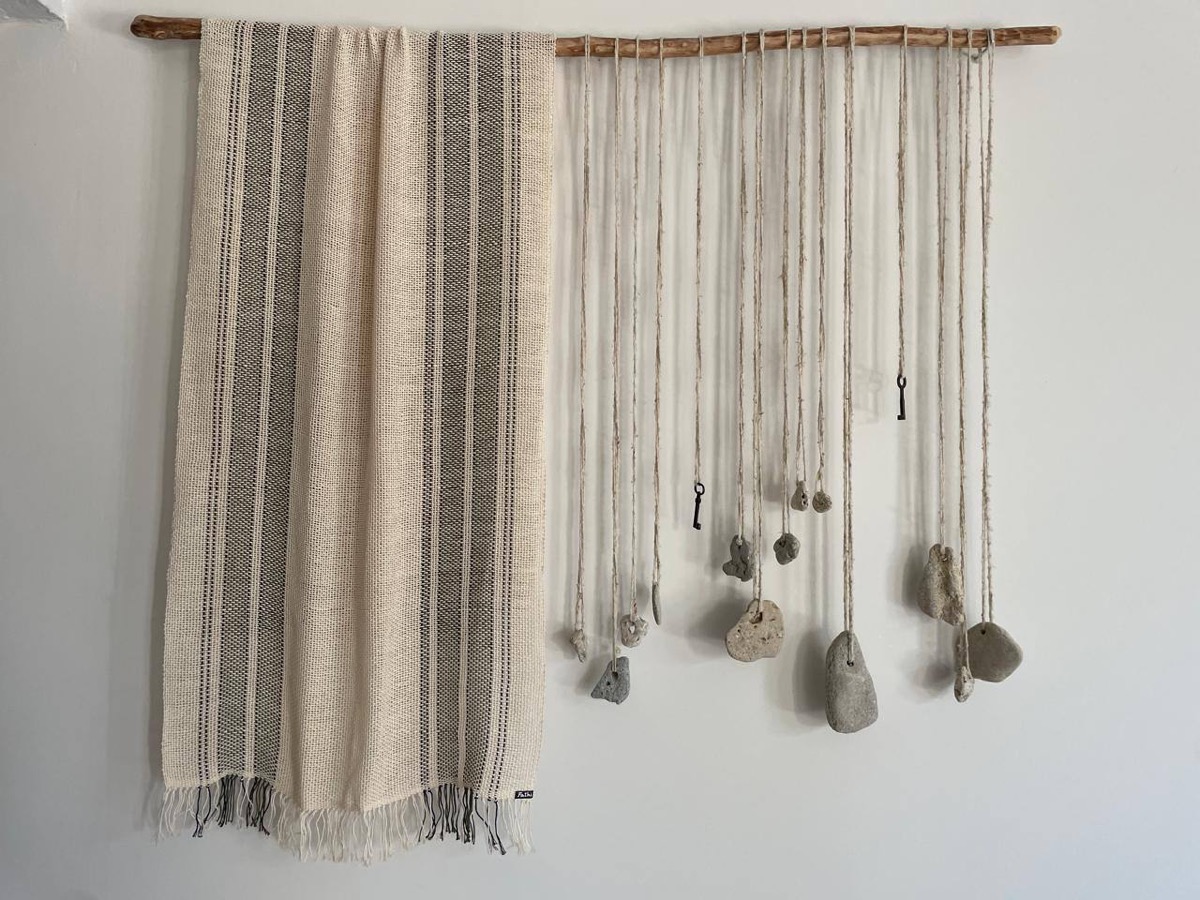 Beach stones hung on threads, a wall piece