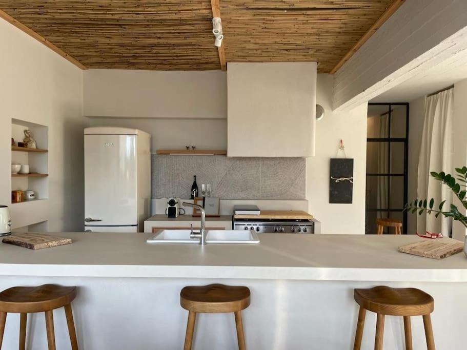 The kitchen island and stools under the reed ceiling
